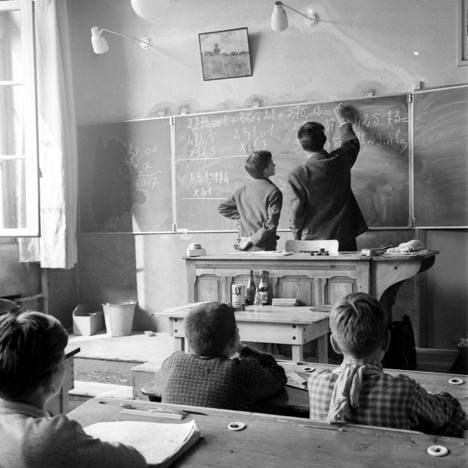 Périmètre d’intervention et expertises Un enseignant explique au tableau à des élèves attentifs dans une classe d'école.