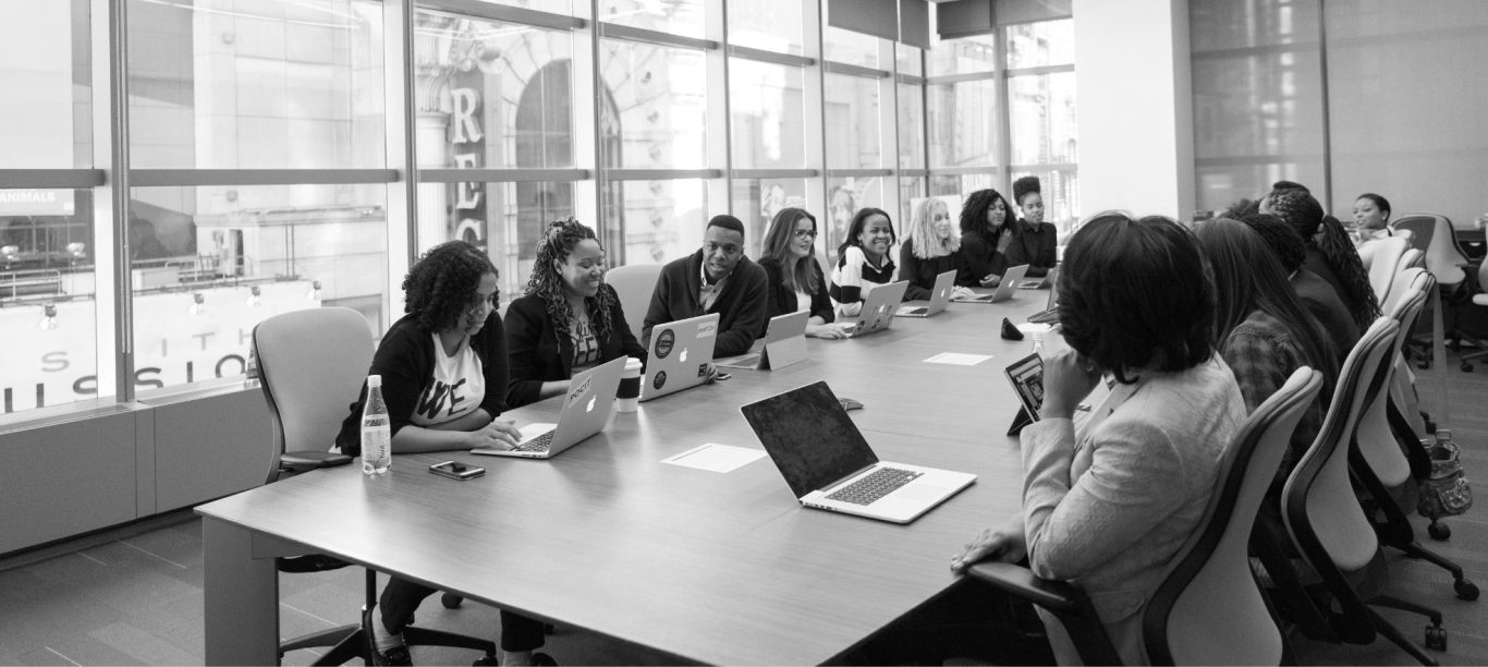 Réunion professionnelle autour d'une grande table avec des participants en discussion.