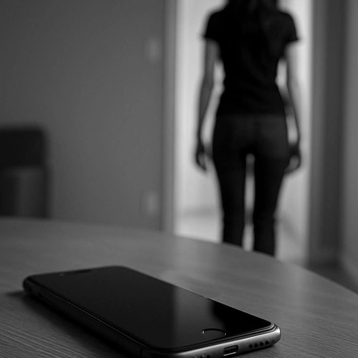 Blog : actualités communication et insights Un téléphone portable sur une table, avec une personne en arrière-plan floue qui s'éloigne.